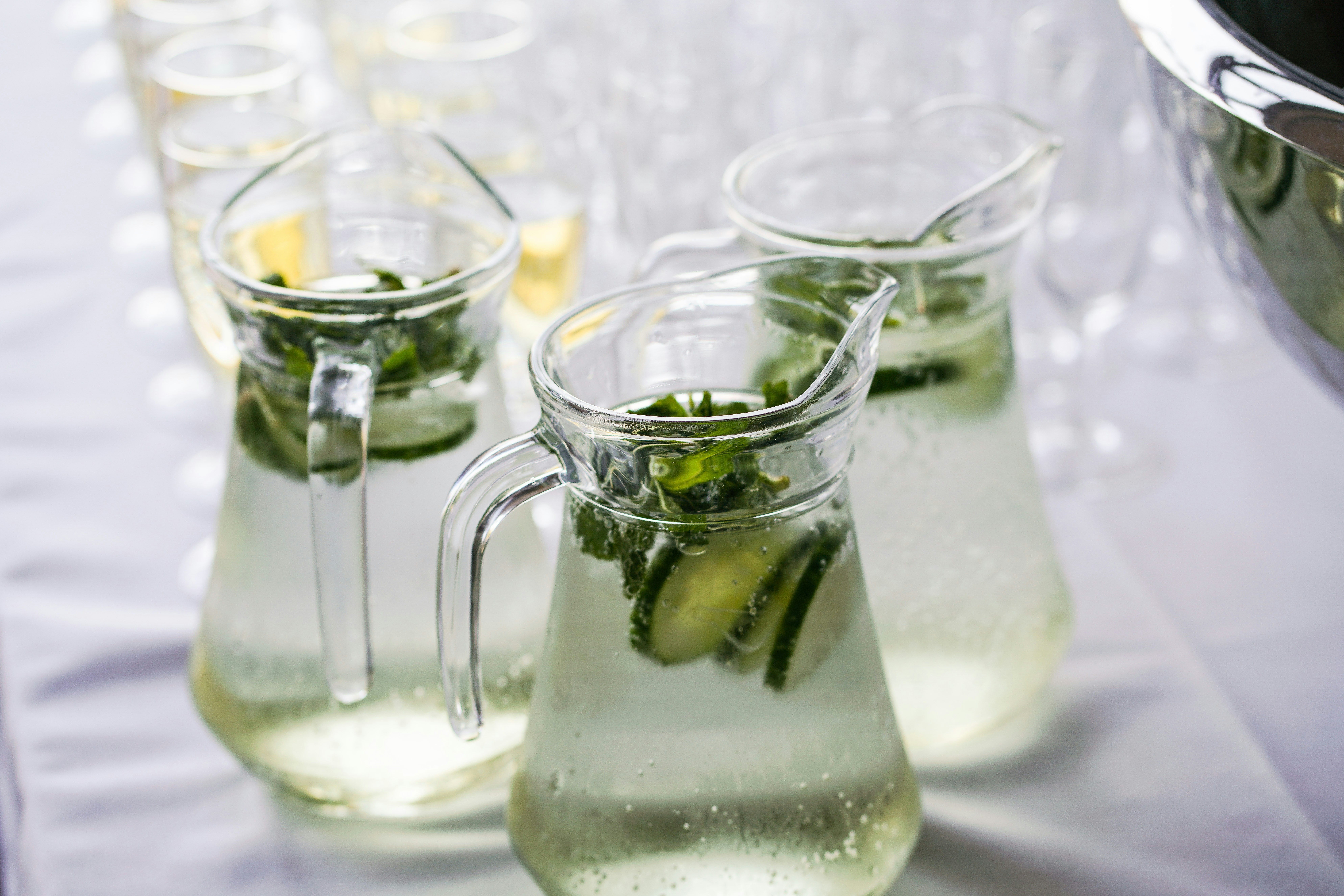 Glass pitchers of cucumber and mint infused water